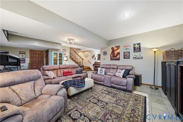 a living room with furniture a ceiling fan and a rug