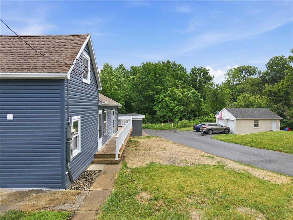 5641 North Coplay Road Whitehall, PA 18052 - Photo 59 of 68 A well-maintained facade features blue siding and a welcoming wooden porch leading to a separate garage structure.