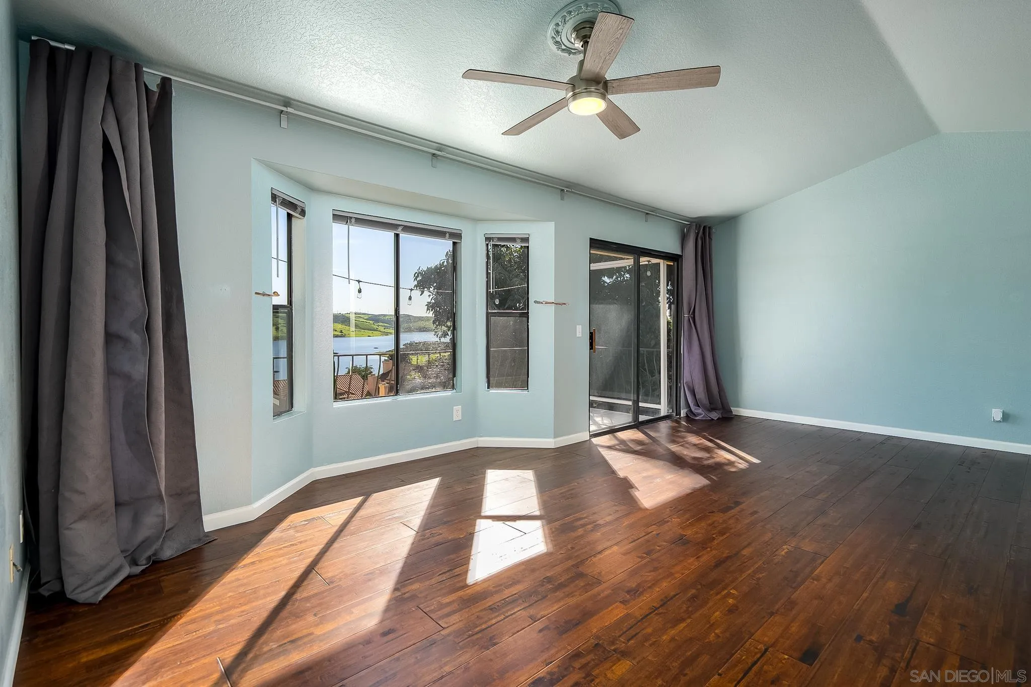 10137 Greenleaf Road Spring Valley, CA 91977 - Photo 19 of 58 a view of an empty room with a window and wooden floor