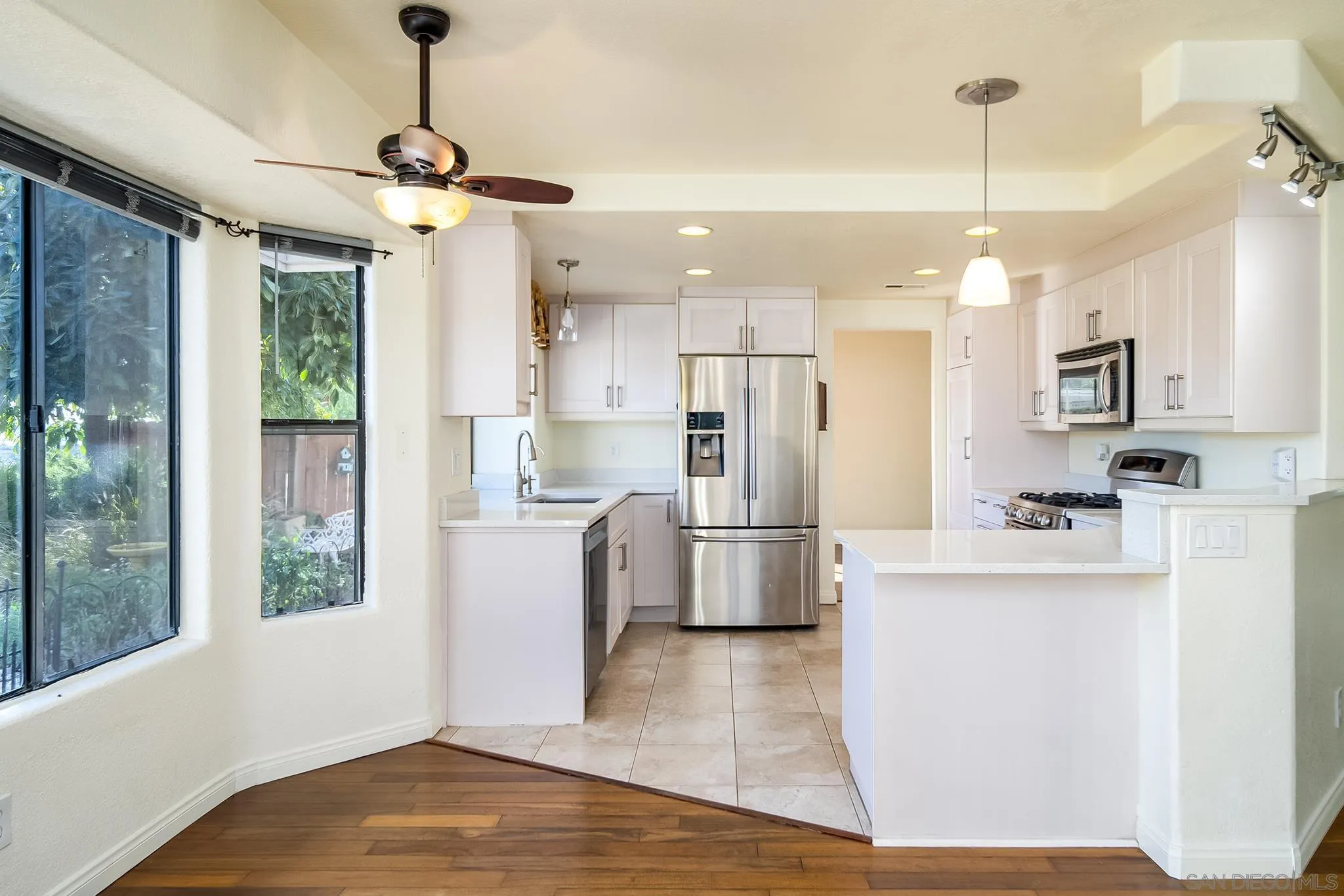 10137 Greenleaf Road Spring Valley, CA 91977 - Photo 10 of 58 a kitchen that has a refrigerator a stove and white cabinets with wooden floor