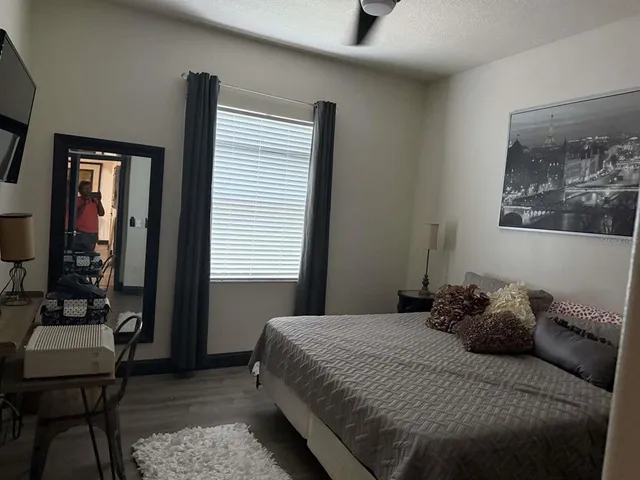 a bedroom with a bed and wooden floor