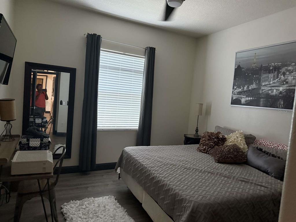 6568 Millstone Drive New Port Richey, FL 34655 - Photo 18 of 26 a bedroom with a bed and wooden floor