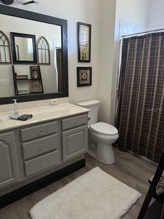 6568 Millstone Drive New Port Richey, FL 34655 - Photo 20 of 26 a bathroom with a toilet sink and mirror