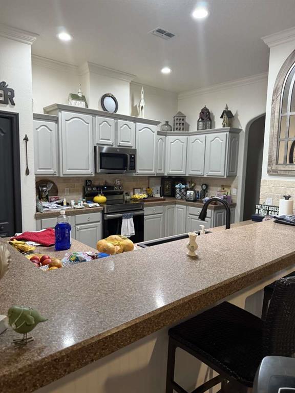 6568 Millstone Drive New Port Richey, FL 34655 - Photo 24 of 26 a kitchen with stainless steel appliances granite countertop a sink refrigerator and cabinets