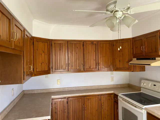 a kitchen with wooden cabinets and white appliances