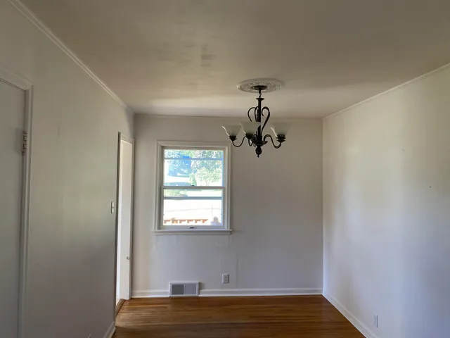 a view of a room with a window and wooden floor