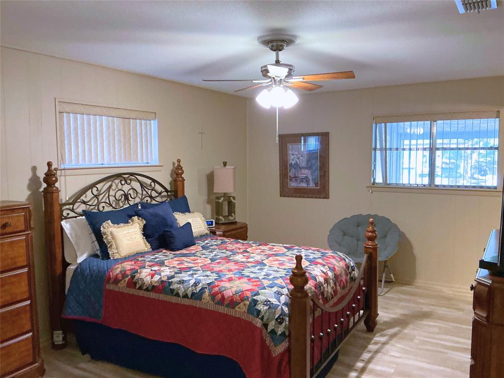 1818 Boot Hill Road Granbury, TX 76049 - Photo 11 of 23 a bedroom with a large bed and a chandelier