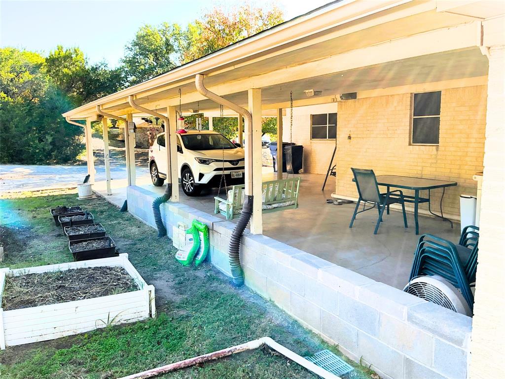1818 Boot Hill Road Granbury, TX 76049 - Photo 19 of 23 a view of a patio with table and chairs with wooden floor and fence