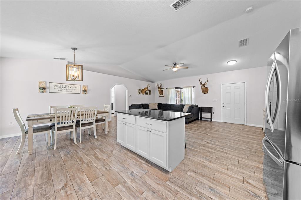 3198 Cherokee Road St. Cloud, FL 34772 - Photo 13 of 43 a kitchen with stainless steel appliances a dining table chairs and wooden floor