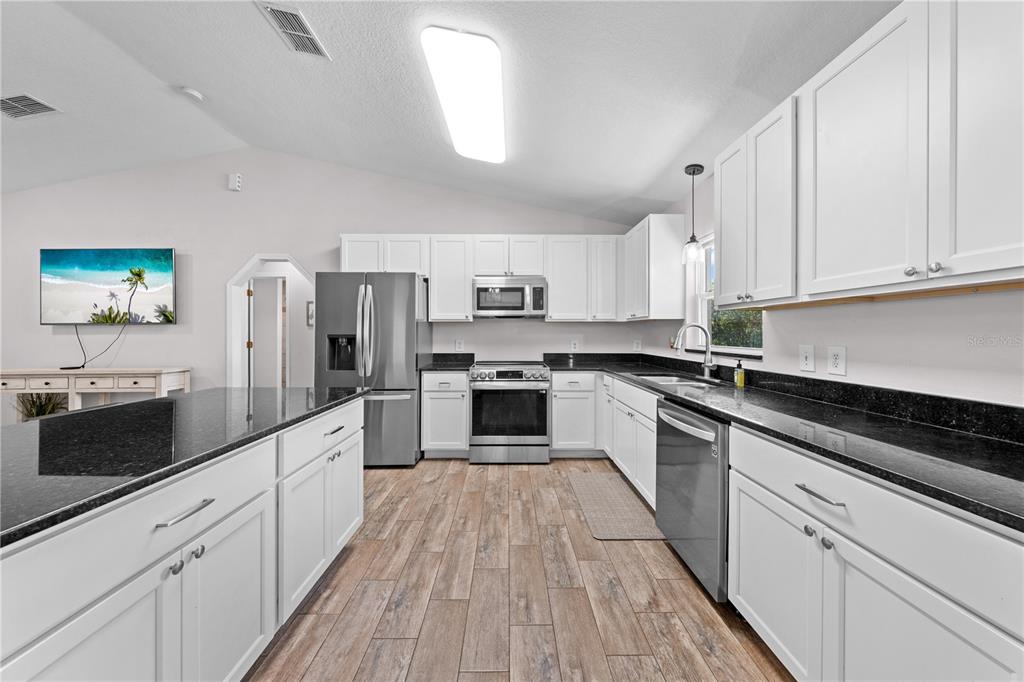 3198 Cherokee Road St. Cloud, FL 34772 - Photo 16 of 43 a large kitchen with cabinets stainless steel appliances and a window