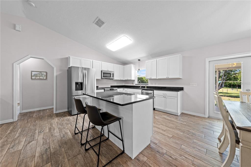 3198 Cherokee Road St. Cloud, FL 34772 - Photo 20 of 43 a kitchen with stainless steel appliances a microwave a stove a sink dishwasher and a refrigerator
