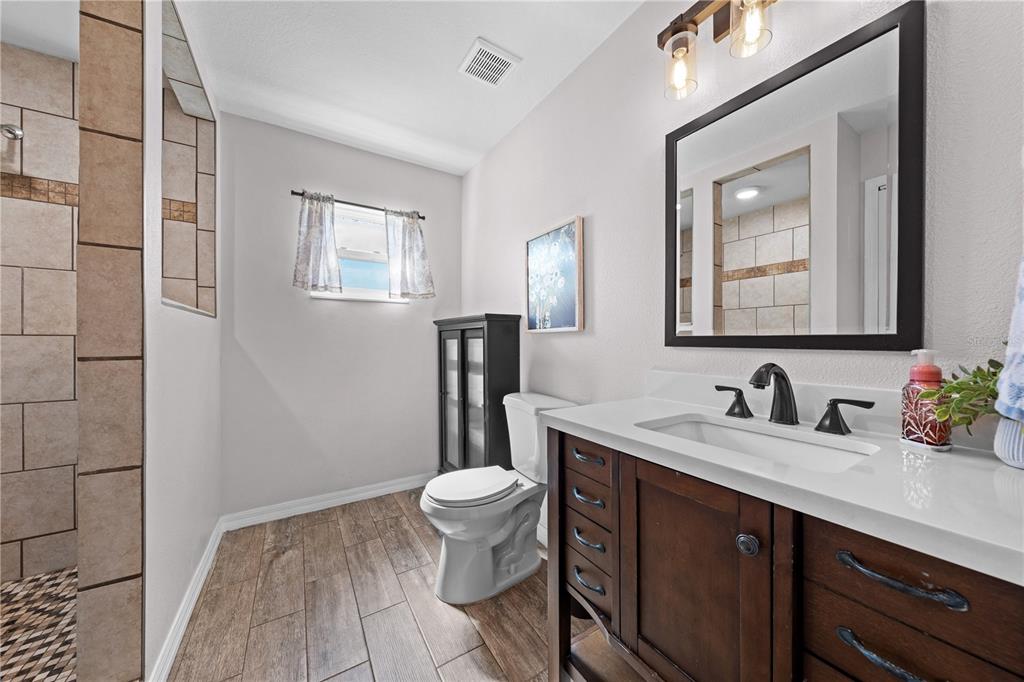 3198 Cherokee Road St. Cloud, FL 34772 - Photo 31 of 43 a bathroom with a sink a toilet and mirror