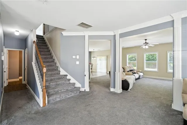 a view of a livingroom with furniture and staircase
