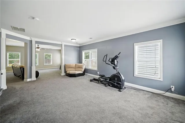 a living room with furniture a gym equipment and a window