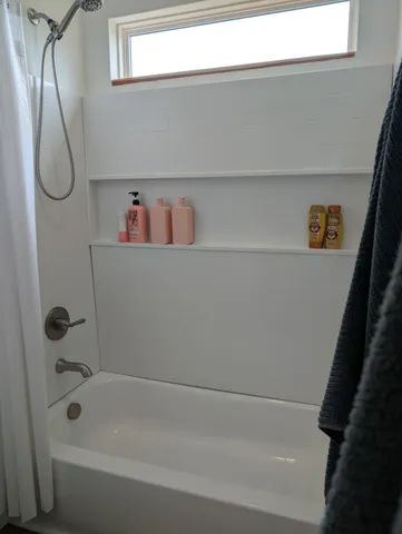 a bathroom with a bathtub and shower