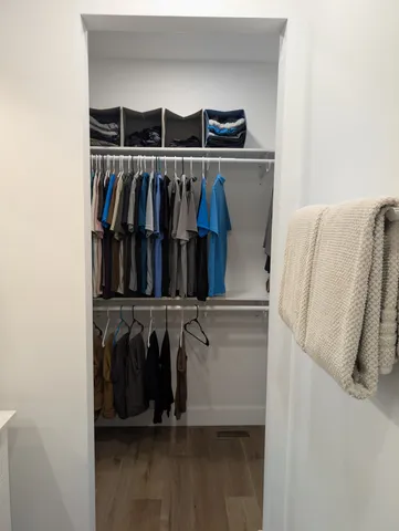 a view of walk in closet with clothes and shoes