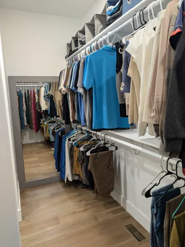 a view of walk in closet with clothes and shoes