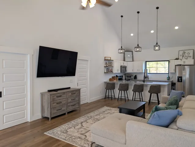 a living room with furniture a flat screen tv and kitchen view