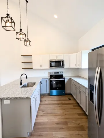 a kitchen with stainless steel appliances granite countertop a sink stove and refrigerator