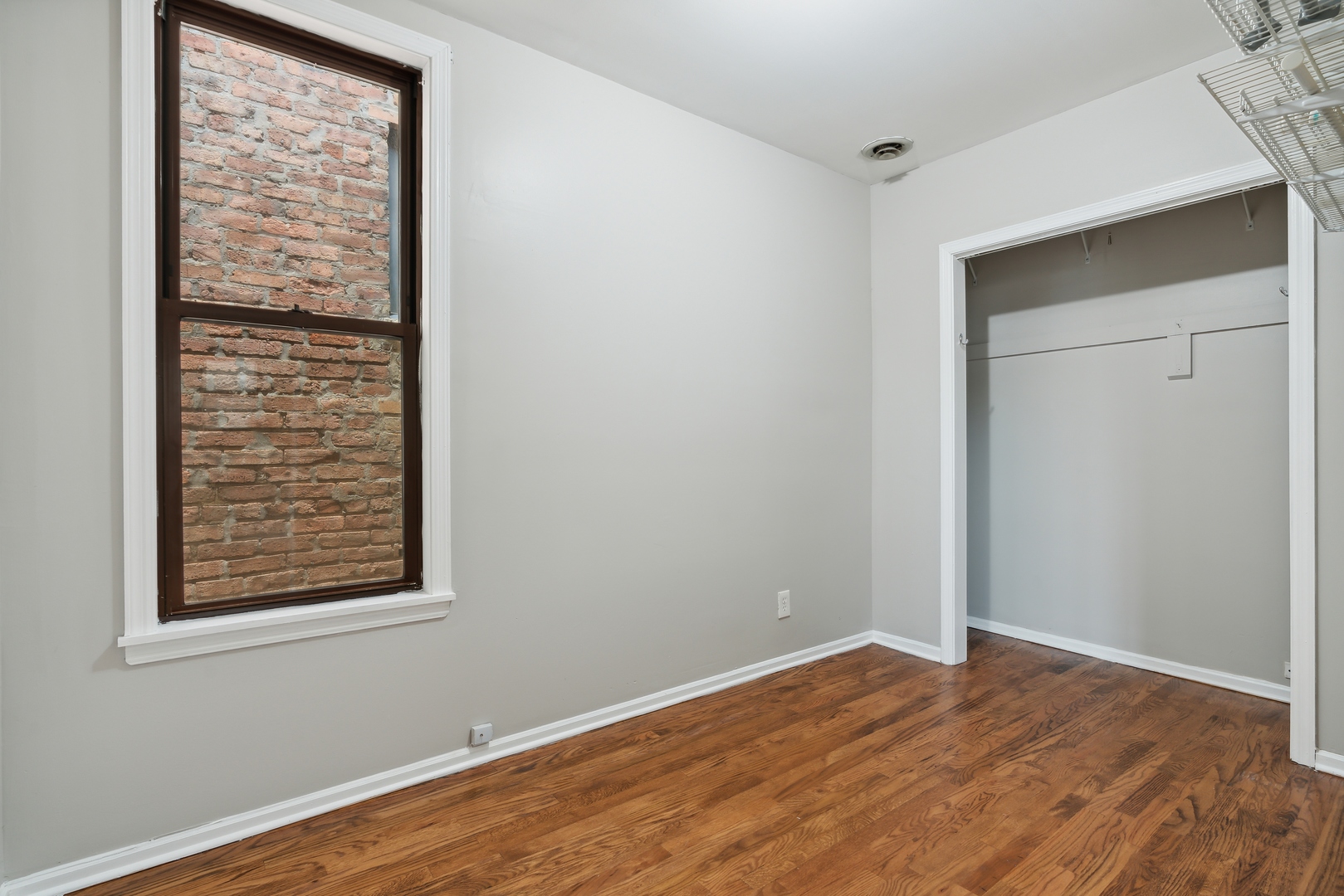 1439 West Lexington Street Chicago, IL 60607 - Photo 14 of 22 a view of an empty room with wooden floor and a window