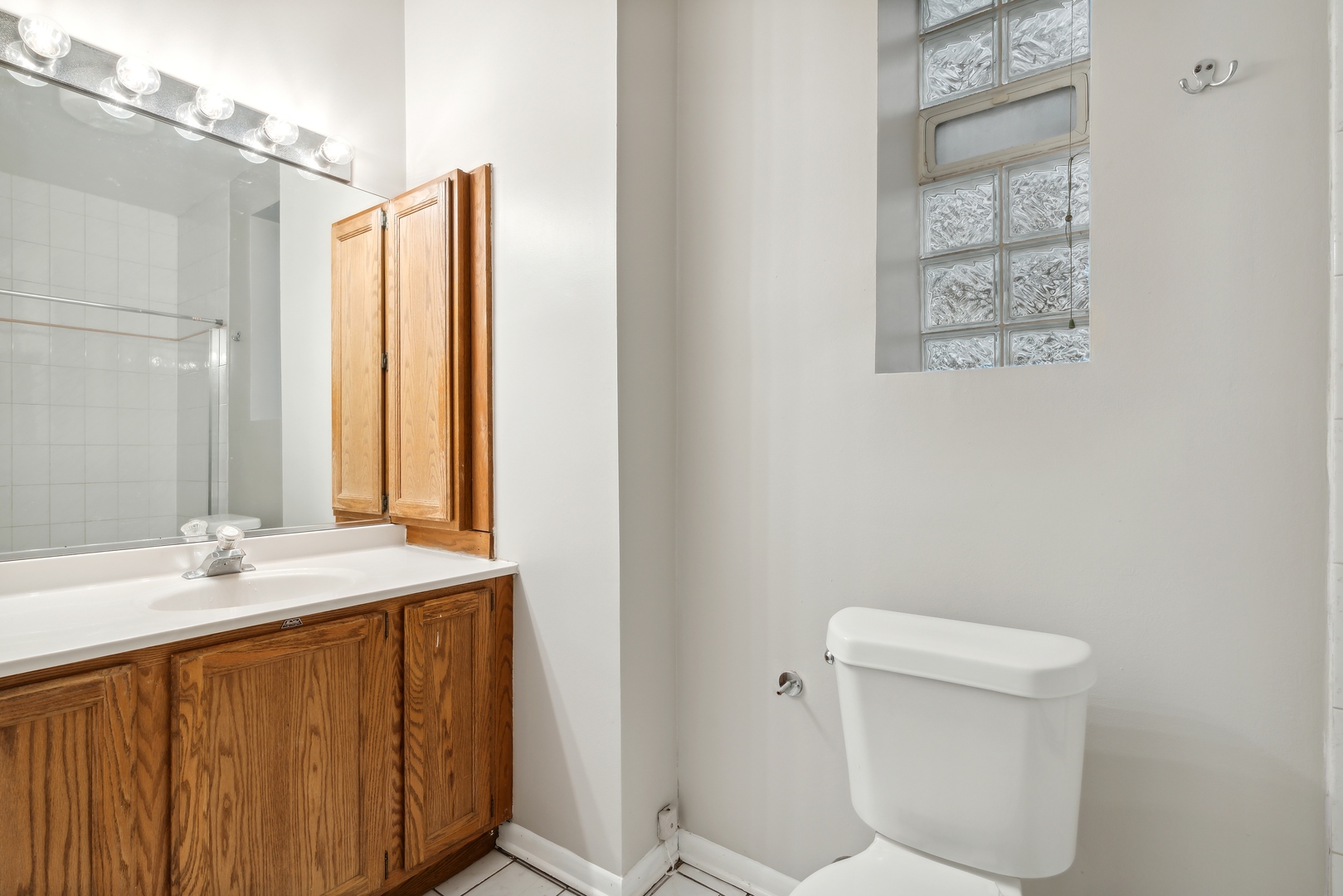 1439 West Lexington Street Chicago, IL 60607 - Photo 17 of 22 a bathroom with a sink a toilet and mirror