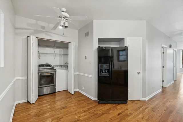 a view of a kitchen with a sink refrigerator and wooden floor