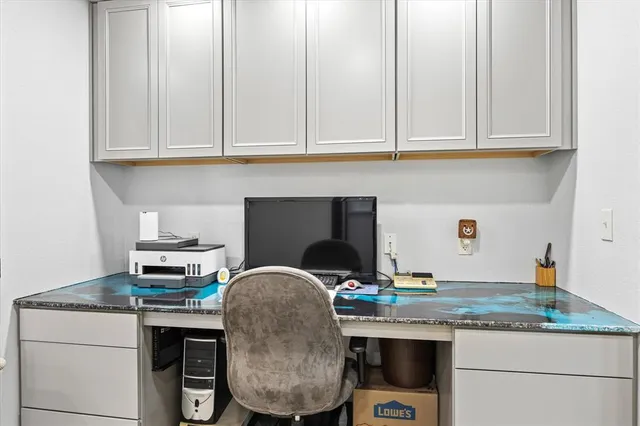 a view of a room that has a bed and a table in it