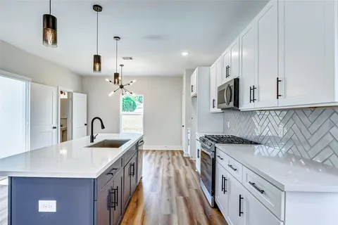a kitchen with stainless steel appliances granite countertop a sink a stove and a refrigerator