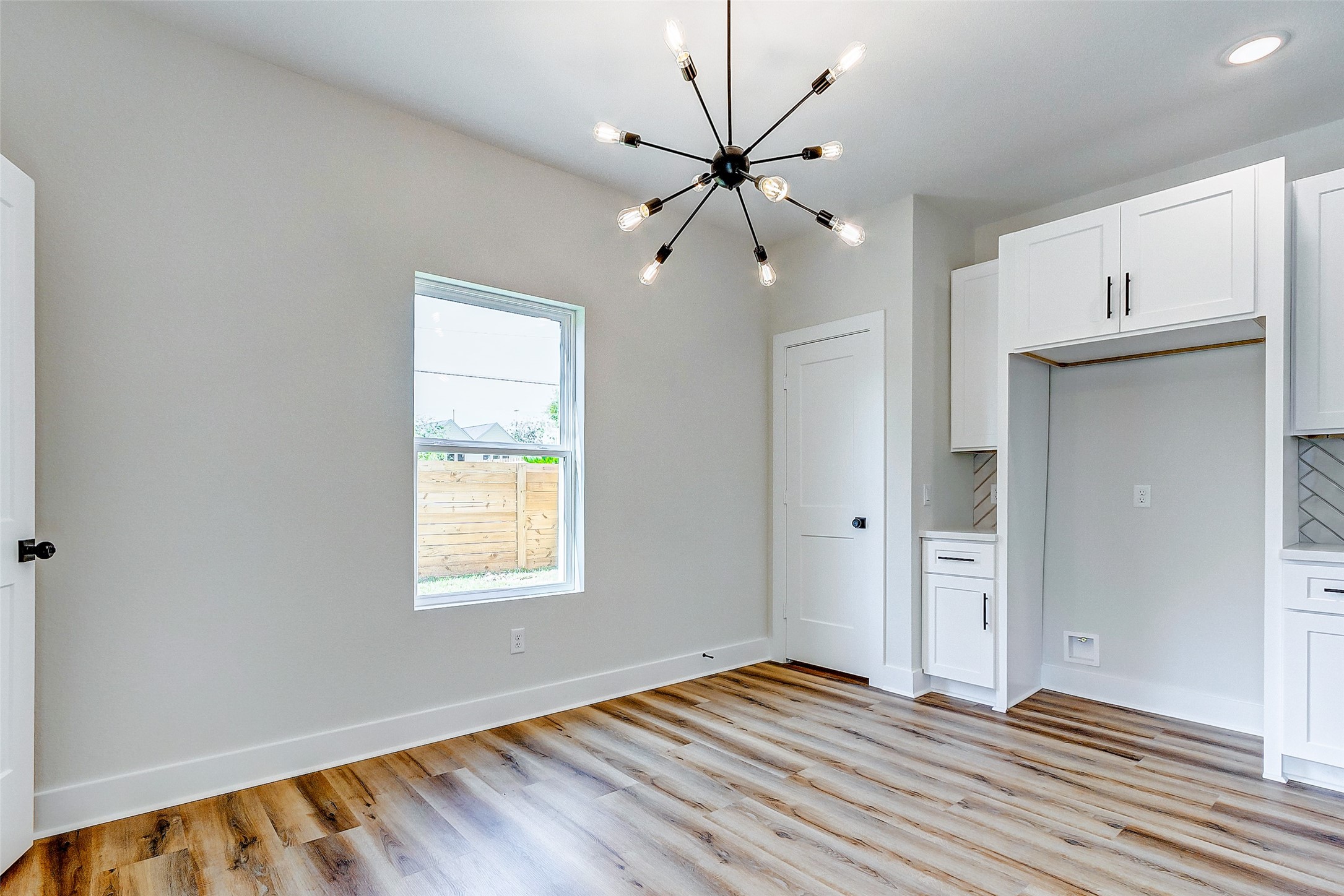 5407 Lee Street Houston, TX 77020 - Photo 18 of 36 a view of an empty room with chandelier fan and wooden floor