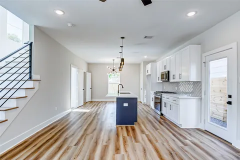a large kitchen with kitchen island a sink stainless steel appliances and cabinets