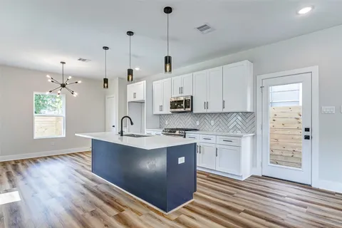 a kitchen with kitchen island a sink stainless steel appliances and cabinets