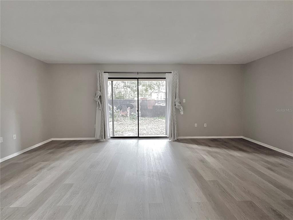 507 Northwest 39th Road, Unit 312 Gainesville, FL 32607 - Photo 11 of 34 a view of an empty room with wooden floor and a window