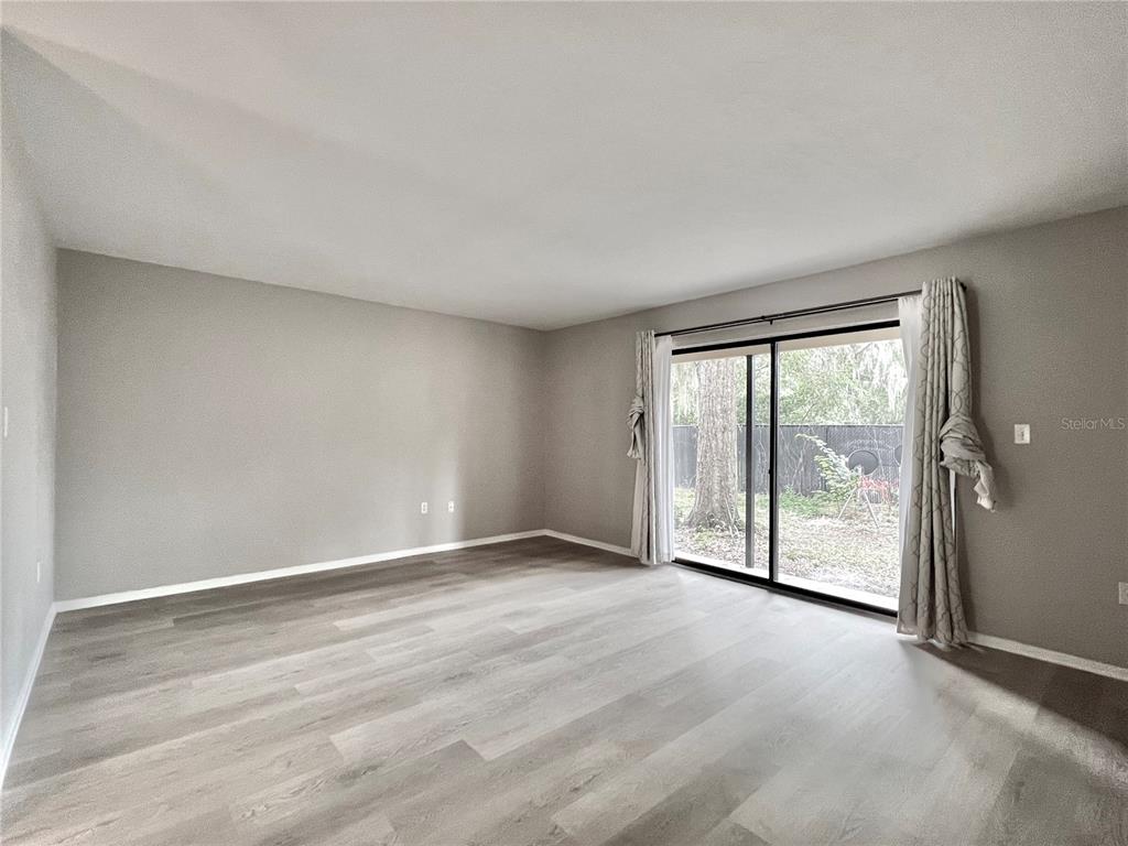 507 Northwest 39th Road, Unit 312 Gainesville, FL 32607 - Photo 12 of 34 a view of an empty room with wooden floor and a window
