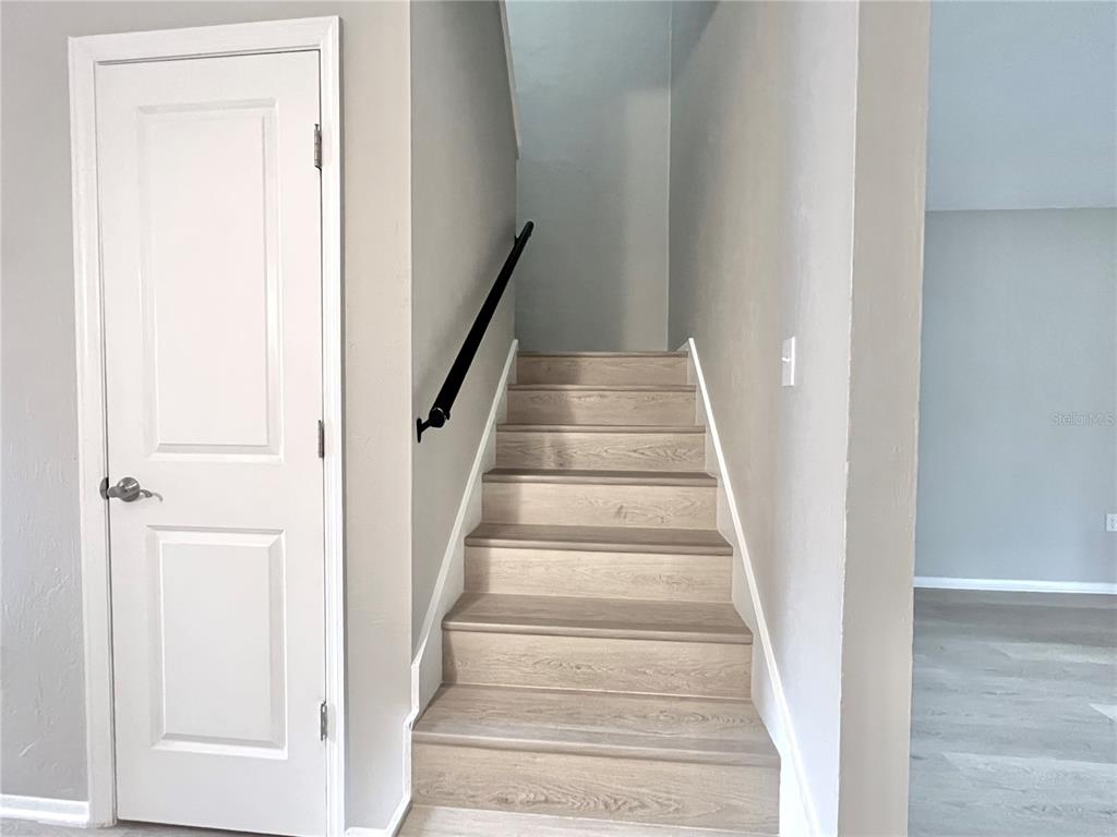 507 Northwest 39th Road, Unit 312 Gainesville, FL 32607 - Photo 13 of 34 a view of staircase with white walls and white door