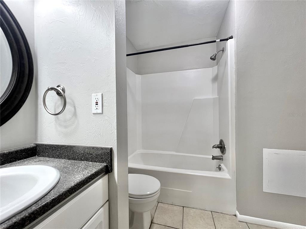 507 Northwest 39th Road, Unit 312 Gainesville, FL 32607 - Photo 17 of 34 a bathroom with a granite countertop sink toilet and shower