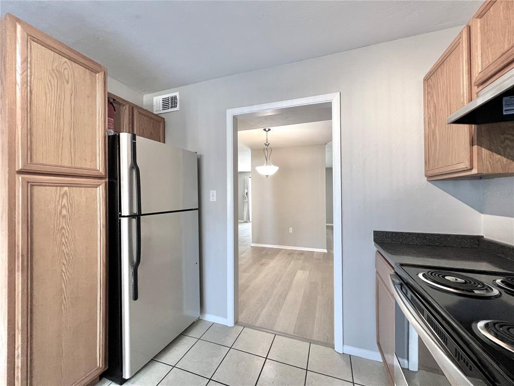 507 Northwest 39th Road, Unit 312 Gainesville, FL 32607 - Photo 8 of 34 a kitchen with a refrigerator and a stove top oven