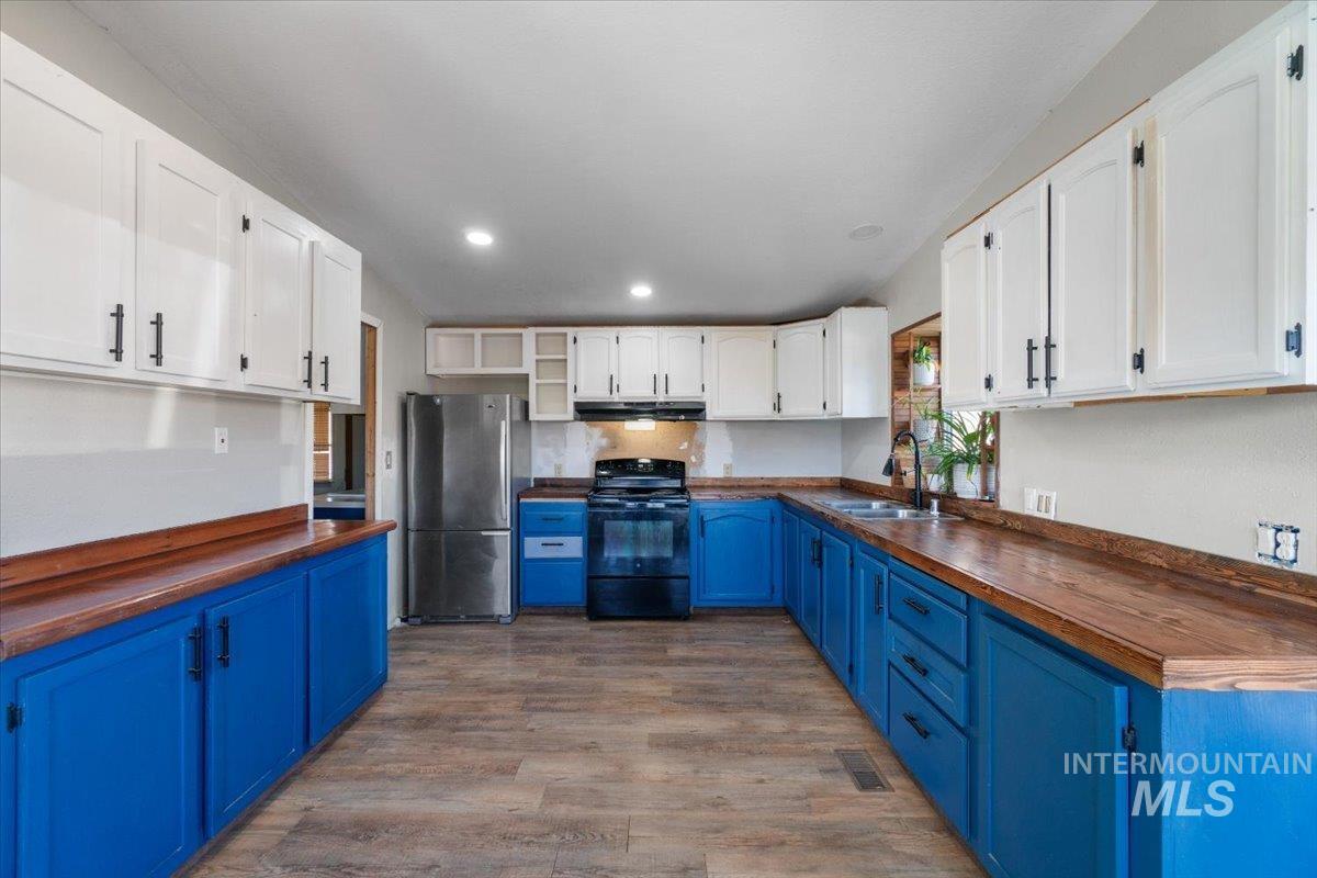 2284 Weiser River Road Weiser, ID 83672 - Photo 15 of 43 Kitchen featuring wooden counters, blue cabinetry, open shelves, white cabinets, and recessed lighting