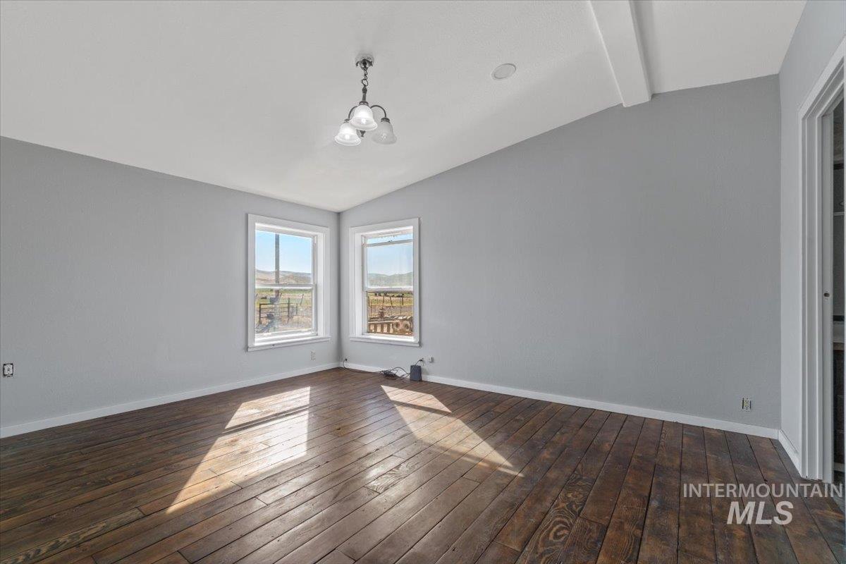 2284 Weiser River Road Weiser, ID 83672 - Photo 18 of 43 Unfurnished room featuring dark wood-style flooring and a chandelier