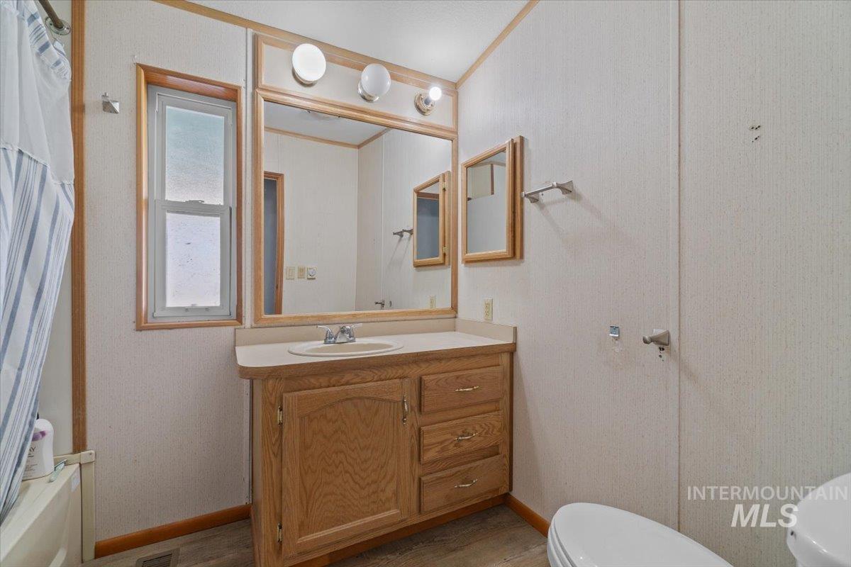 2284 Weiser River Road Weiser, ID 83672 - Photo 24 of 43 Full bath with vanity, light wood-type flooring, and ornamental molding