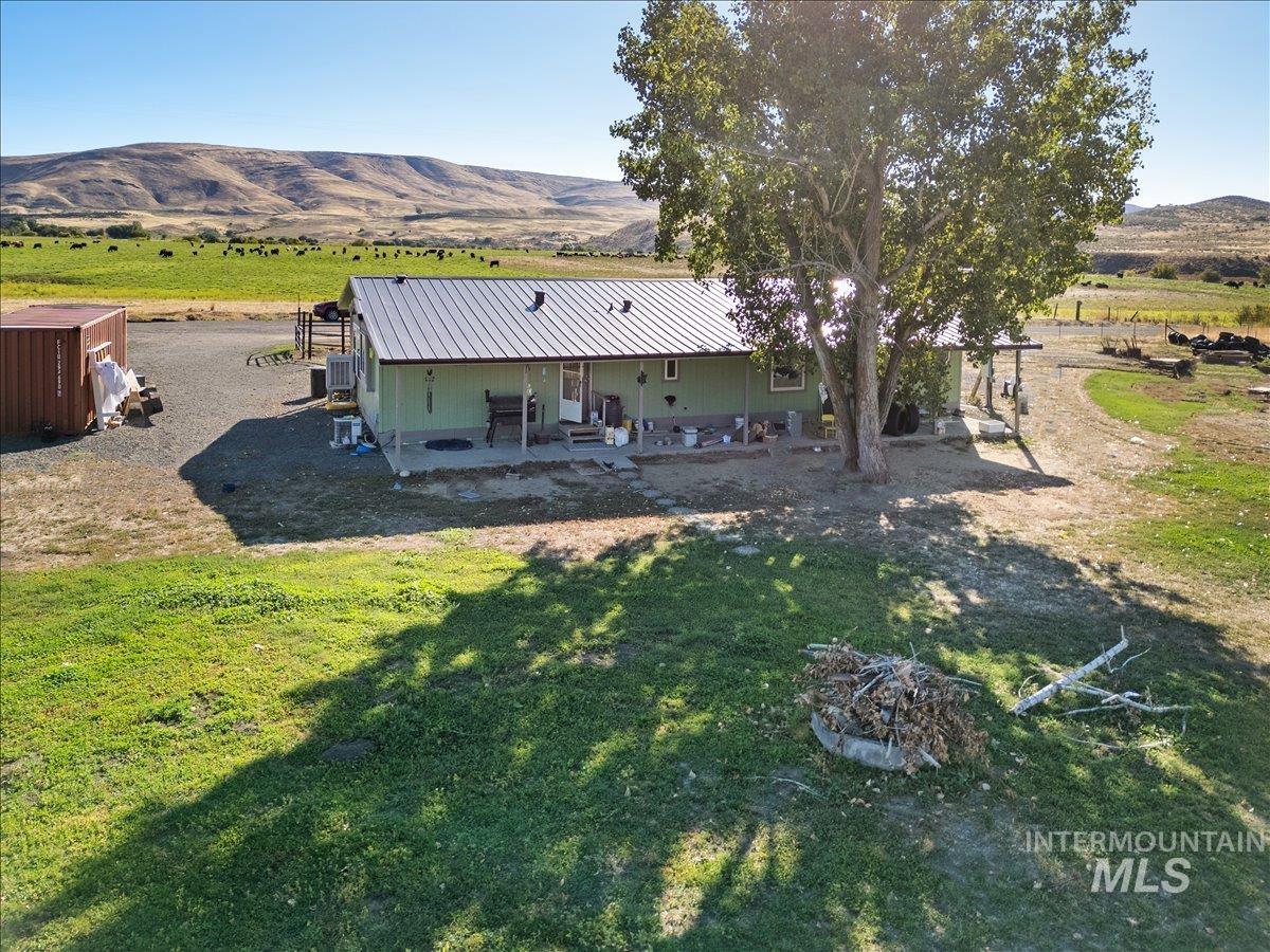 2284 Weiser River Road Weiser, ID 83672 - Photo 29 of 43 Rear view of property featuring a mountain view, a patio, a metal roof, and a yard