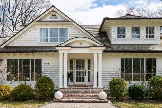 65 Mill Road New Canaan, CT 06840 - Photo 2 of 42 a front view of a house with a yard