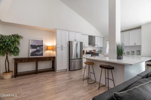 a living room with furniture a flat screen tv and kitchen view