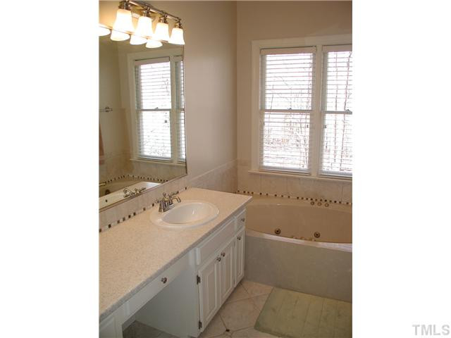 10721 Dunhill Terrace Raleigh, NC 27615 - Photo 10 of 19 Master bath has been updated with solid surface counter tops & double sink vanity, tiled floors & backsplash, etc. Double shower heads in a separate shower. Double door linen closet. Vaulted ceiling with skylight above whirlpool tub. Master Bath/Spa