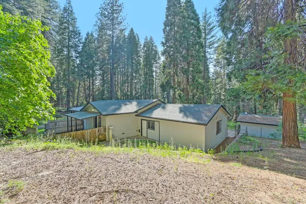 a view of a house with backyard and trees