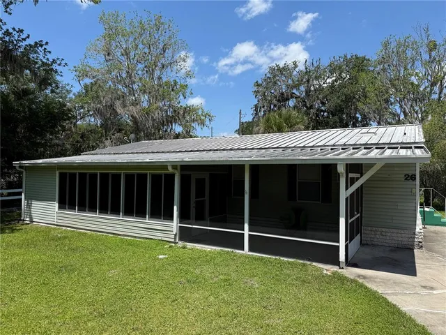 a view of a house with a yard and sitting area