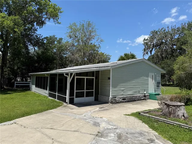 a view of a house with a yard and large tree