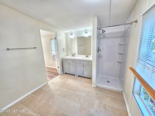 a view of an empty room with window and wooden floor
