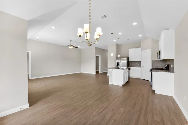 a view of a kitchen with kitchen island a sink stainless steel appliances and cabinets