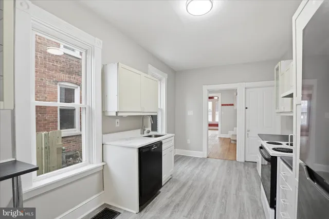 a kitchen with a wooden floor window and stainless steel appliances