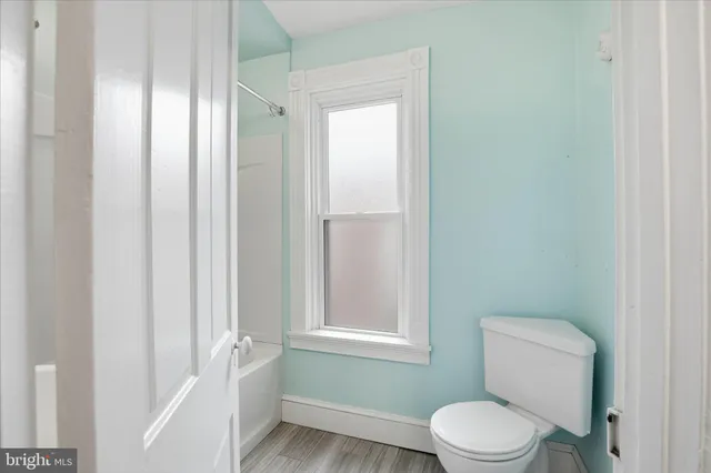 a white toilet sitting next to a bathroom sink and vanity
